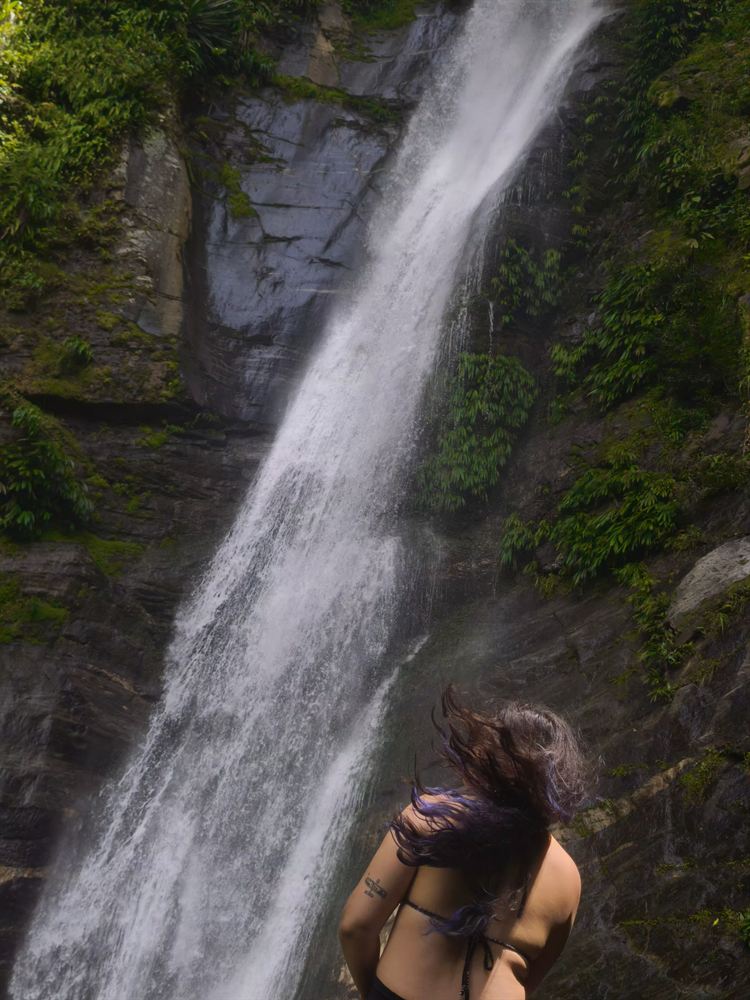 Visitante disfrutando la cascada